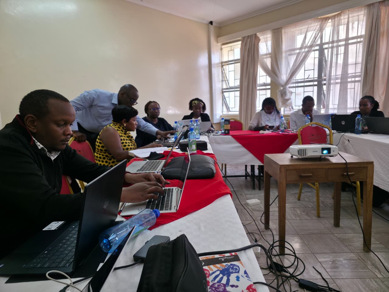 Technical officers from the State Department for Forestry (SDF), Grievance Redress Mechanism (GRM) focal persons, and the Information and Communication Technology Authority (ICTA) engage in discussions during the validation meeting of the KEWASIP website and GRM module at KALRO, Naivasha.
